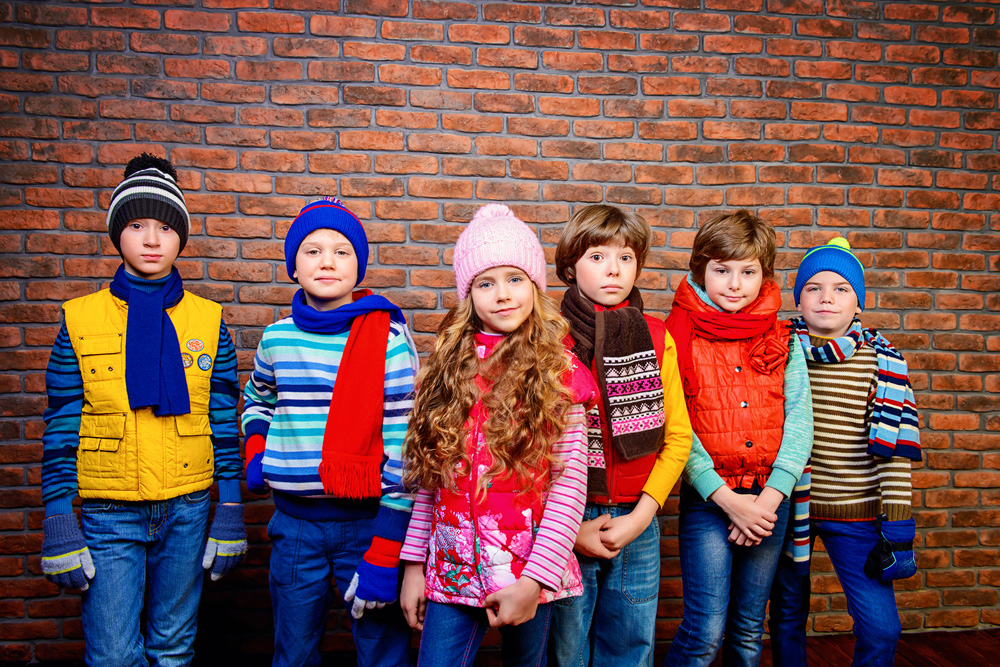 Foto di gruppo di bimbi in abbigliamento invernale. Jeans, maglioni e cappelli in lana colorati