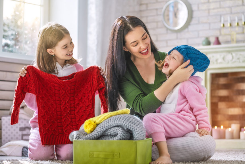 Moda bimbi inverno. Mamma con due bimbi che scelgono nuovi vestiti