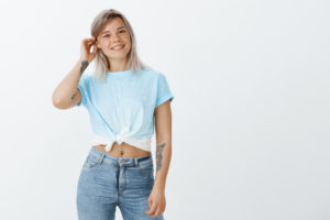 Ragazza che indossa jeans azzurro chiaro a vita alta in abbinamento a camicetta azzurro cielo annodata in vita con piccoli pois bianchi