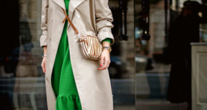 Particolare di abito verde abbinato a trench crema e mini bag crema e marrone