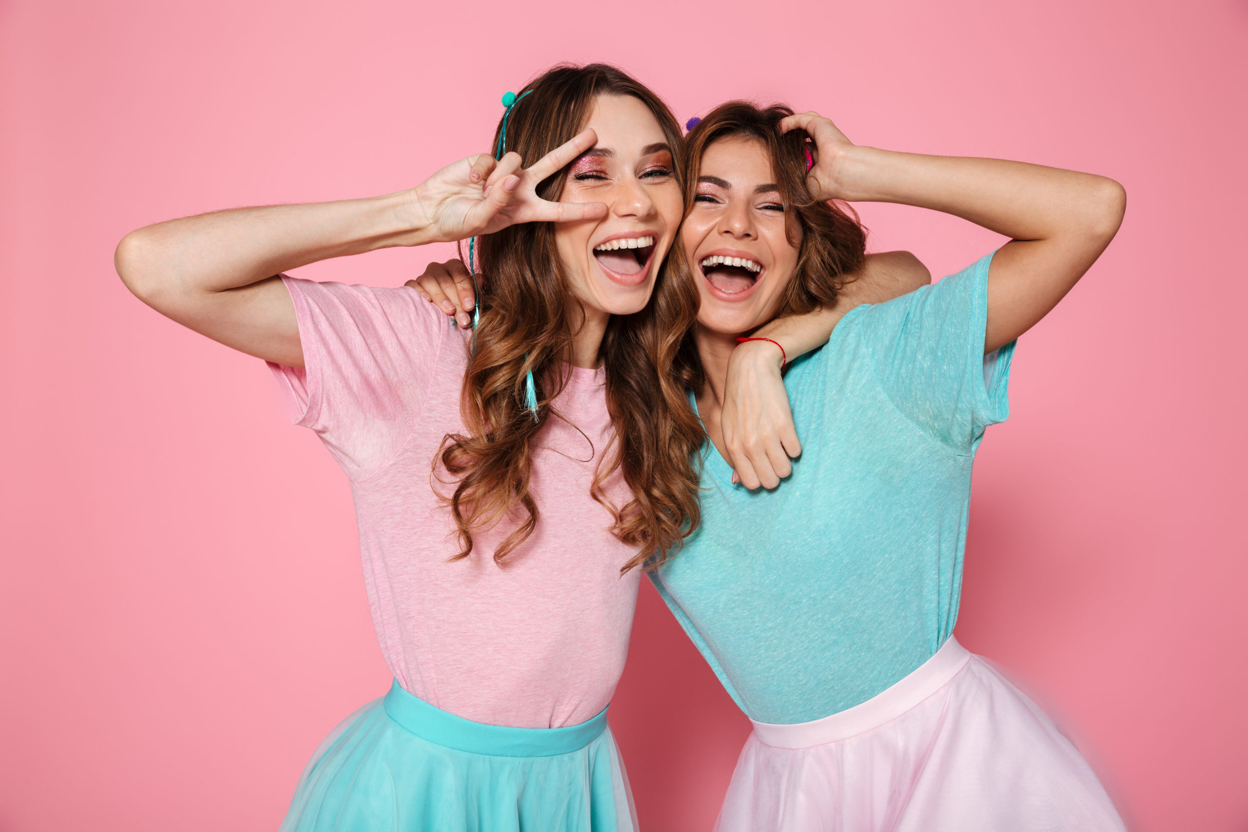 Due ragazze che indossano abbinamento di due colori. Uno con gonna turchese e t shirt rosa e l'altro con gonna rosa e t shirt turchese