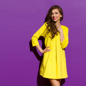 Ragazza che indossa abito giallo lime su sfondo viola