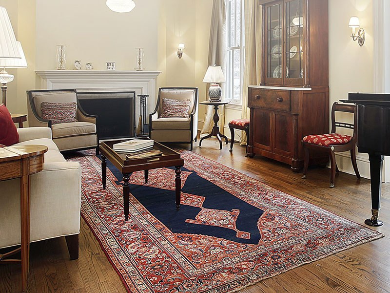 Particolare di salotto con tappeto persiano nei toni del blu e rosso
